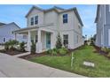 Charming two-story home featuring a welcoming front porch and a well-manicured lawn at 196 Eagleston Ln, Lakewood Ranch, FL 34240
