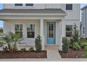 Close-up of a charming light-blue front door with surrounding landscaping and columns at 196 Eagleston Ln, Lakewood Ranch, FL 34240