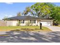 Well-maintained one-story home with a black metal roof, black shutters and a two-car garage on a lush lawn at 3001 Paul Buchman Hwy, Plant City, FL 33563