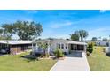 Inviting single-story home with a covered porch and carport, landscaped yard, and a lovely front facade at 8461 Buttonquail Dr, Englewood, FL 34224