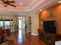 Bright living room with gleaming hardwood floors, open to the kitchen, and dining area at 5271 Visionary Ct, Sarasota, FL 34233