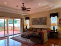 Cozy living room featuring hardwood floors, a ceiling fan, and sliding glass doors to the deck at 5271 Visionary Ct, Sarasota, FL 34233