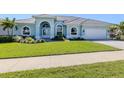 Beautiful one-story home with arched windows, a well-maintained lawn, and a two-car garage at 519 Purslane Pt, Venice, FL 34293