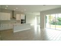 A bright, open kitchen with modern appliances, a center island, and sliding doors to the backyard at 9572 Brave Buck Ave, Land O Lakes, FL 34638