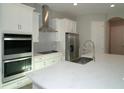 Modern kitchen with an island, stainless steel appliances, and white cabinets at 9620 Brave Buck Ave, Land O Lakes, FL 34638