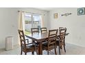 Bright dining area featuring a wooden table with seating for six, a sliding glass door, and neutral décor at 38370 Sonnet Landing Ave, Zephyrhills, FL 33540