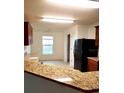 Bright kitchen space featuring granite countertops, black appliances, and tile flooring at 6698 Wirevine Dr, Brooksville, FL 34602