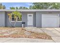 Inviting home exterior featuring a front entrance framed by palm trees and a neatly manicured lawn and an attached garage at 5330 Dr Martin Luther King Jr St S, St Petersburg, FL 33705