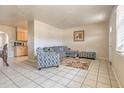Living room boasts tile flooring, an area rug, a modern grey sofa and complementary patterned accent chair at 5330 Dr Martin Luther King Jr St S, St Petersburg, FL 33705
