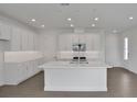 Modern, all-white kitchen with a large center island, stainless steel appliances, and ample counter space at 200 Eagleston Ln, Lakewood Ranch, FL 34240