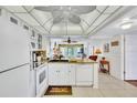 Well-lit kitchen with a ceiling fan, granite countertops, white appliances, and an adjacent living area at 12300 Vonn Rd # 1102, Largo, FL 33774