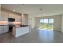 Open-concept kitchen with an island, stainless steel appliances, and lots of natural light at 9270 Gulf Haven Dr, Parrish, FL 34219