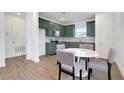 Eat in kitchen with olive green cabinets, stainless steel appliances, and stylish tile backsplash at 9608 Brave Buck Ave, Land O Lakes, FL 34638