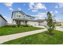 Beautifully landscaped front yard leading to a charming two-story home with a spacious three-car garage at 11728 June Briar Loop, San Antonio, FL 33576