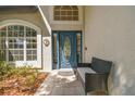 Charming front door with decorative glass and a cozy bench on the porch at 17904 Singing Wood Pl, Lutz, FL 33548