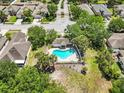 Aerial view of community pool with heart shape, mature trees, and surrounding residential homes at 14820 Potterton Cir, Hudson, FL 34667