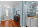Inviting foyer with hardwood floors, a built-in bar area, and soft blue walls at 14820 Potterton Cir, Hudson, FL 34667