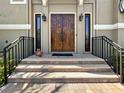 Inviting front entrance with a solid wood double door, sidelights, and decorative sconces at 7020 Hawks Harbor Cir, Bradenton, FL 34207