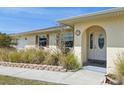 Welcoming front entrance featuring a white door, an arched doorway, and decorative window shutters at 3067 Iverson St, Port Charlotte, FL 33952
