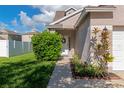 Inviting home entrance with a vibrant green shrub, garden bed, and a well-manicured lawn at 4135 Rocky Fork Ter, Ellenton, FL 34222