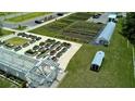 Aerial view of a sprawling community garden with raised beds, greenhouses, and ample parking at 17677 Nectar Flume Dr, Land O Lakes, FL 34637
