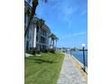 Scenic view of a waterfront condo building with a paved walkway along the water's edge and lush green landscaping at 4310 Falmouth Dr # 301, Longboat Key, FL 34228