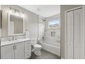 Bathroom featuring white vanity, tub with shower, tiled wall and floors, and good lighting at 12534 Chenwood Ave, Hudson, FL 34669