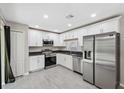 Updated kitchen featuring stainless steel appliances, granite countertops, and white cabinetry at 12534 Chenwood Ave, Hudson, FL 34669