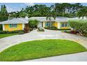 Charming single-story home featuring lush landscaping, a circular driveway and a central fountain at 401 Sunset Dr, Venice, FL 34285