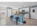 Bright kitchen featuring an island with seating, white cabinetry, stainless steel appliances, and a pantry at 3270 Rock Sound St, Bradenton, FL 34208