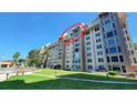 Exterior shot of the condo building on a sunny day with a well-manicured lawn at 632 Edgewater Dr # 832, Dunedin, FL 34698