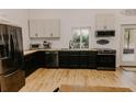 Bright kitchen featuring black bottom cabinets, butcher block countertops, and stainless appliances at 18142 Powerline Rd, Dade City, FL 33523