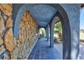 Inviting stone-clad front porch with arched openings and slate tile flooring at 6443 34Th N Ave, St Petersburg, FL 33710