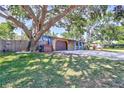 Exterior view of a single story home with attached garage and a spacious front yard with mature trees at 6443 34Th N Ave, St Petersburg, FL 33710