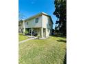 Two-story townhome boasting a lush green lawn and manicured landscaping at 15515 Morning Dr, Lutz, FL 33559