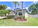 Manicured lawn with palm trees and decorative landscaping enhances curb appeal at 107 Dakota Hill Dr, Seffner, FL 33584