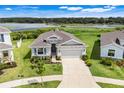 Beautiful home showcasing a well-kept lawn, in a tranquil community near a scenic lake at 13797 Wineberry Dr, Dade City, FL 33525