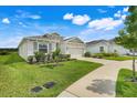 Well-maintained one-story home with lush landscaping, a two-car garage, and a welcoming entrance at 13797 Wineberry Dr, Dade City, FL 33525