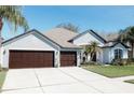 A charming single-story home featuring a three-car garage and a neatly manicured lawn at 26620 Shoregrass Dr, Wesley Chapel, FL 33544