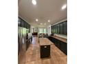 A large kitchen with dark wood cabinets, granite countertops, stainless steel appliances, and a tile floor at 26620 Shoregrass Dr, Wesley Chapel, FL 33544