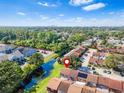 Community aerial view with pond, greenery, and a location pin indicating property's position at 3401 Sunrise Villas S Ct, Tampa, FL 33614