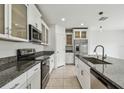 Modern kitchen features white cabinets, granite countertops, stainless steel appliances and tile flooring at 2139 Stellar Brilliance Way, Lutz, FL 33558