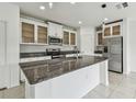 Open kitchen featuring white cabinets, granite countertops, stainless steel appliances, and a center island at 2139 Stellar Brilliance Way, Lutz, FL 33558