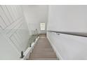Modern staircase with glass railing and light wood steps leading to the upper level at 2139 Stellar Brilliance Way, Lutz, FL 33558