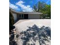 Charming home with a gravel driveway leading to the garage, surrounded by lush landscaping at 4571 Clearwater Harbor S Dr, Largo, FL 33770