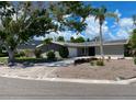 Lovely single-story home with a light grey exterior, palm tree, and brick-paved driveway at 4571 Clearwater Harbor S Dr, Largo, FL 33770