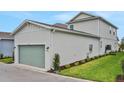 Exterior showing the garage of the house, with its light green doors and adjacent well-maintained lawn at 145 Thorne Ln, Lakewood Ranch, FL 34240