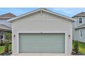 Two car garage with a green door on a new build home at 164 Eagleston Ln, Lakewood Ranch, FL 34240