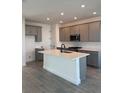 Modern kitchen featuring gray cabinetry, a center island with a sink, and stainless steel appliances at 172 Eagleston Ln, Lakewood Ranch, FL 34240