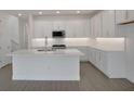 Modern kitchen featuring an island, white cabinetry, stainless steel appliances, and tile floors at 204 Eagleston Ln, Lakewood Ranch, FL 34240